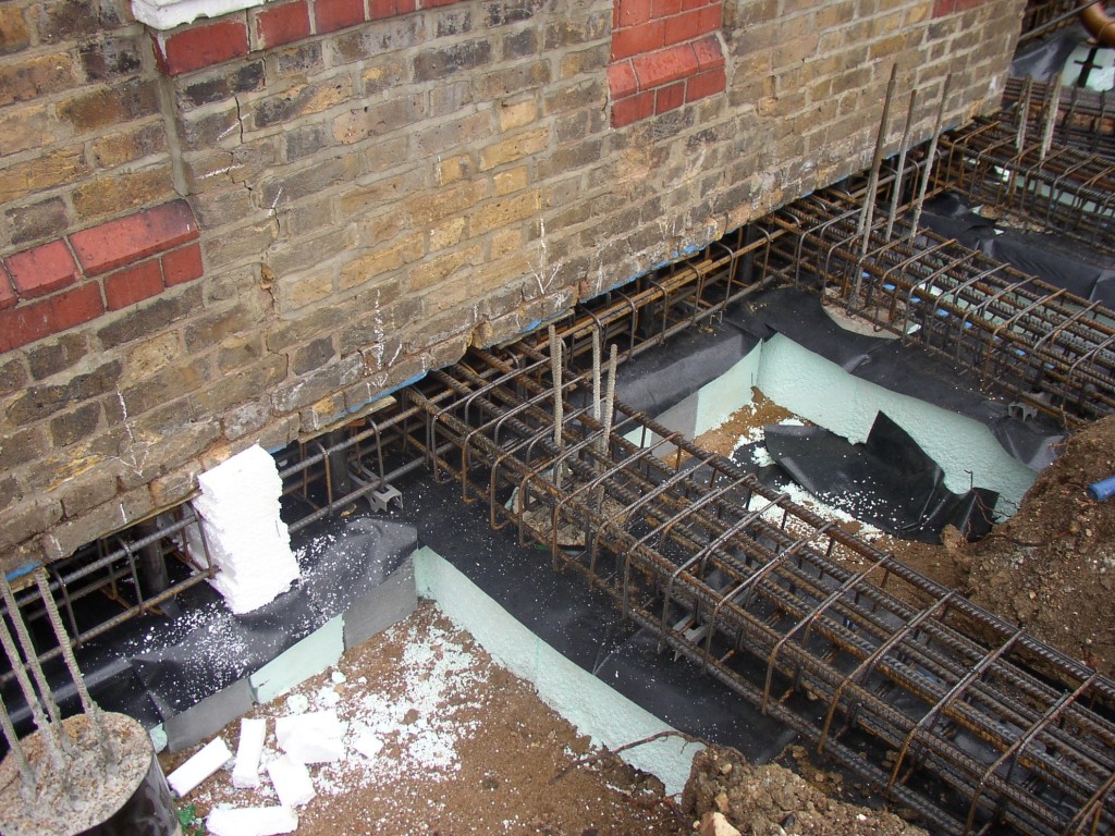 Cantilever pile and beam underpinning.